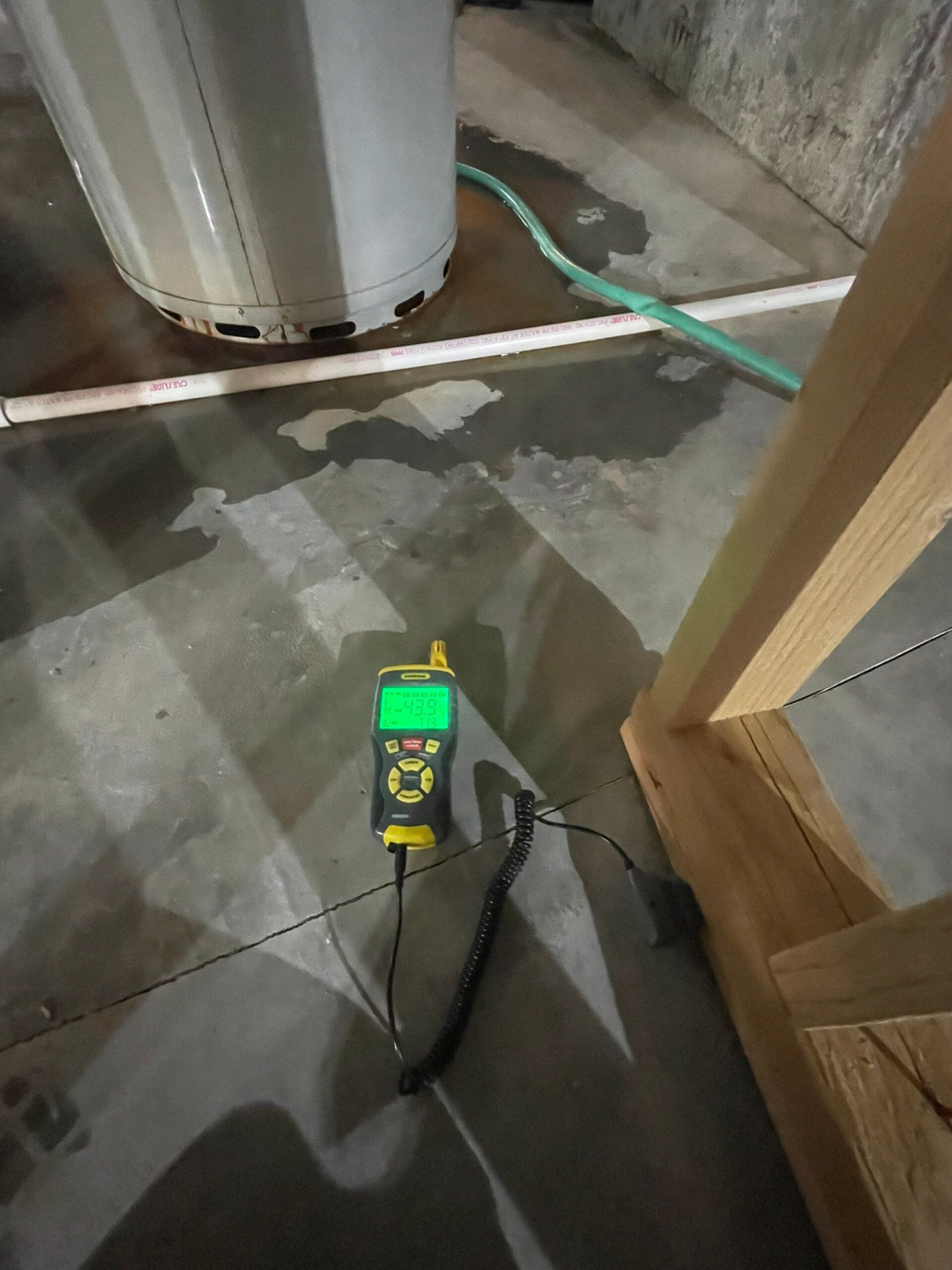 Moisture meter measuring wet concrete during the structural drying phase of water damage restoration in Colorado Springs. Daily moisture monitoring against IICRC S500 standards ensures complete drying.